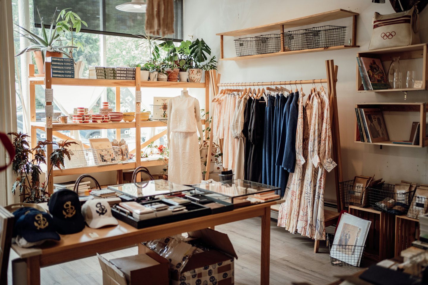 Boutique interior with clothing racks and display tables.