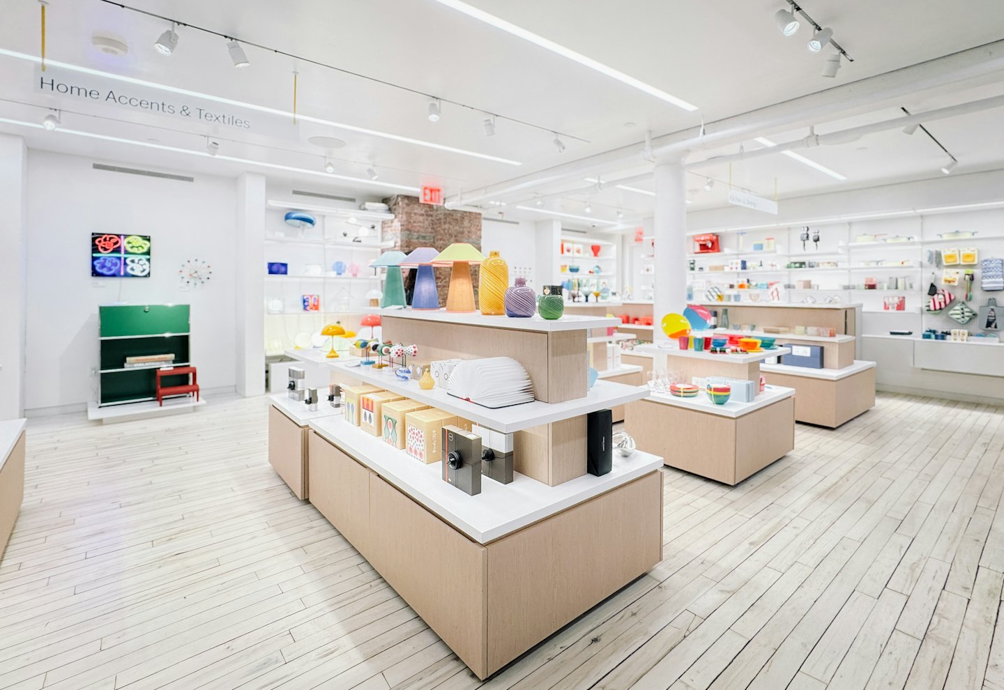 Colorful home decor displayed on shelves in a modern retail store.